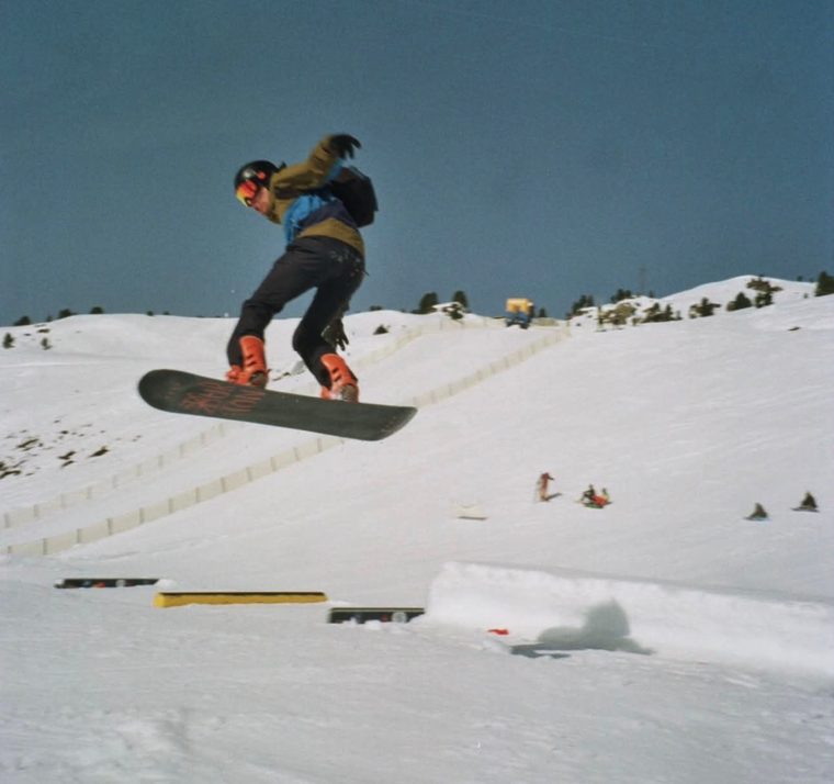 Wessel maakt een sprong op zijn snowboard in een funpark